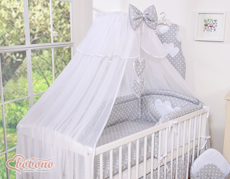 Large mosquito net for baby's bed made of white chiffon with hanging hearts and a bow - dots on gray