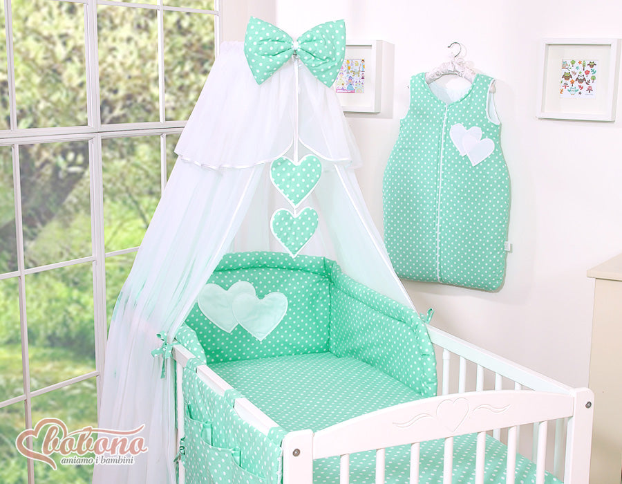 Large mosquito net for baby's bed made of white chiffon with hanging hearts and a bow - dots on mint