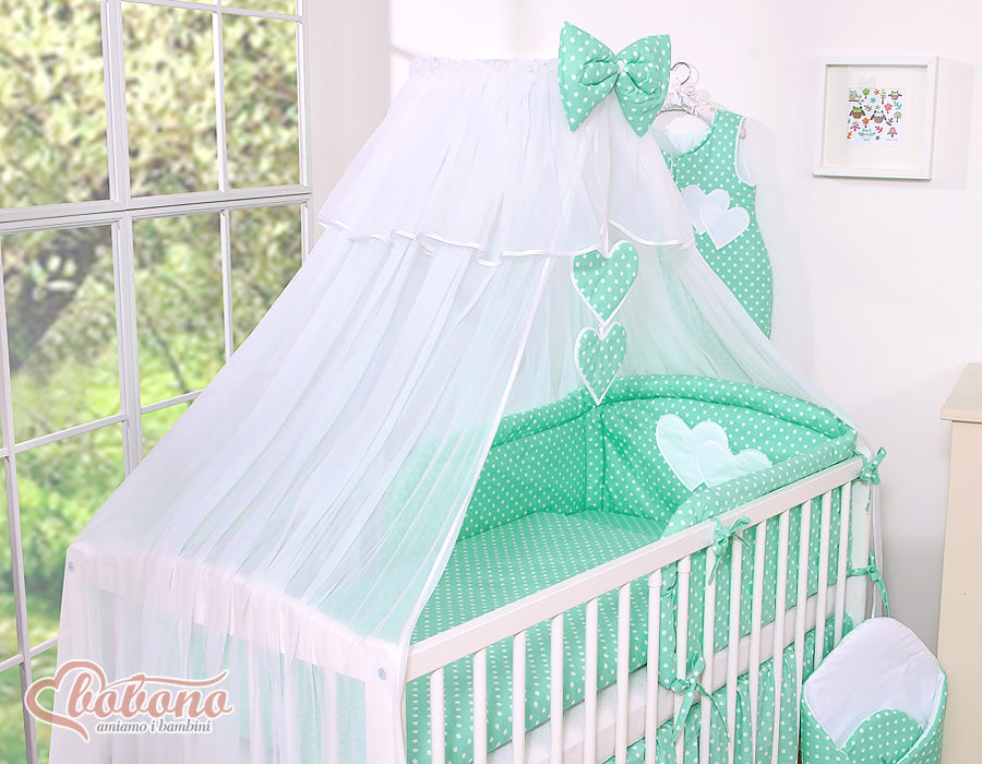 Large mosquito net for baby's bed made of white chiffon with hanging hearts and a bow - dots on mint
